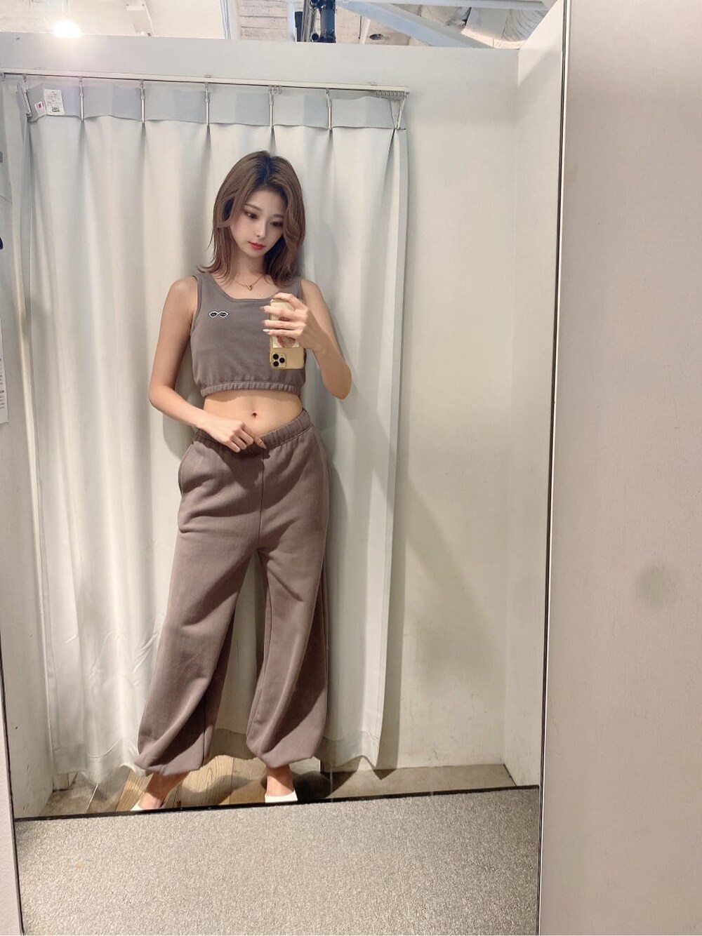 ホワイト系のパンプス、ベージュ系のスウェットパンツ、ベージュ系のタンクトップを着用したレディースの夏コーディネートの1枚目の写真