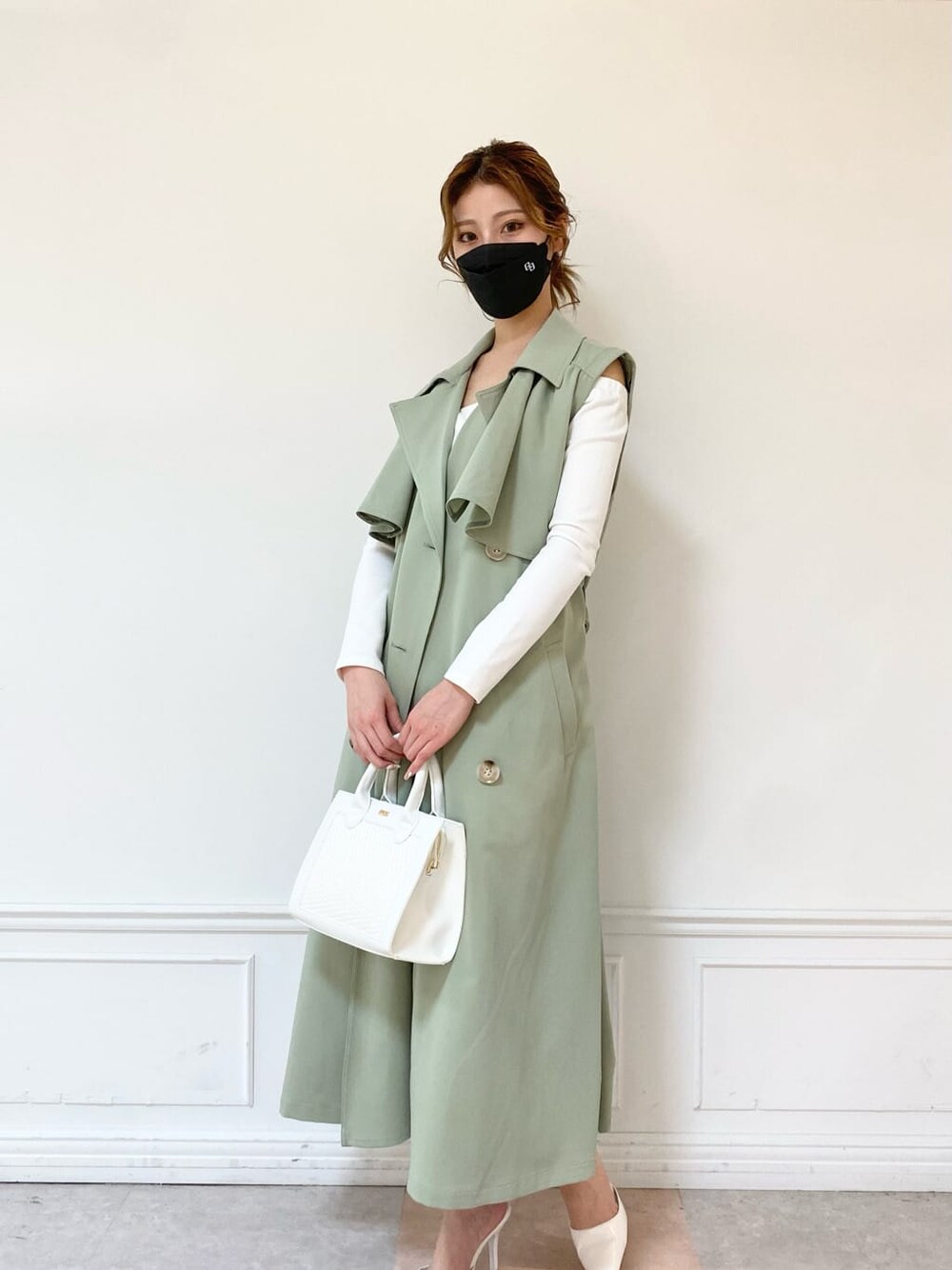 ホワイト系のパンプス、グリーン系のトレンチコート、ホワイト系のTシャツ/カットソーを着用したレディースの春コーディネートの1枚目の写真