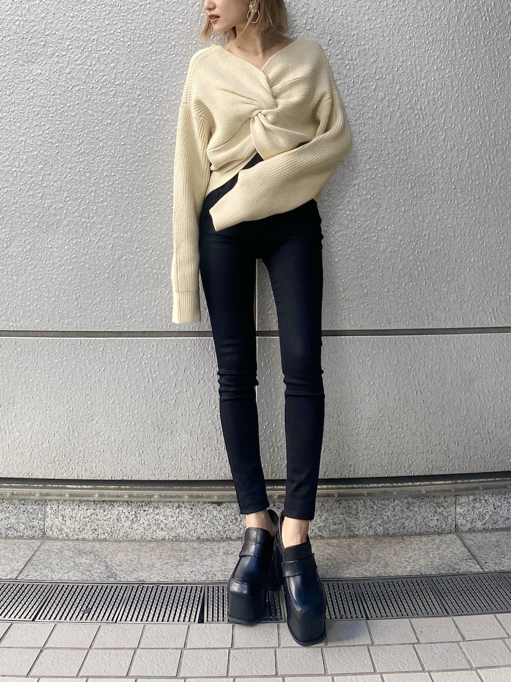 ブラック系のデニムパンツ、ホワイト系のニット/セーター、その他のローファーを着用したレディースの冬コーディネートの1枚目の写真