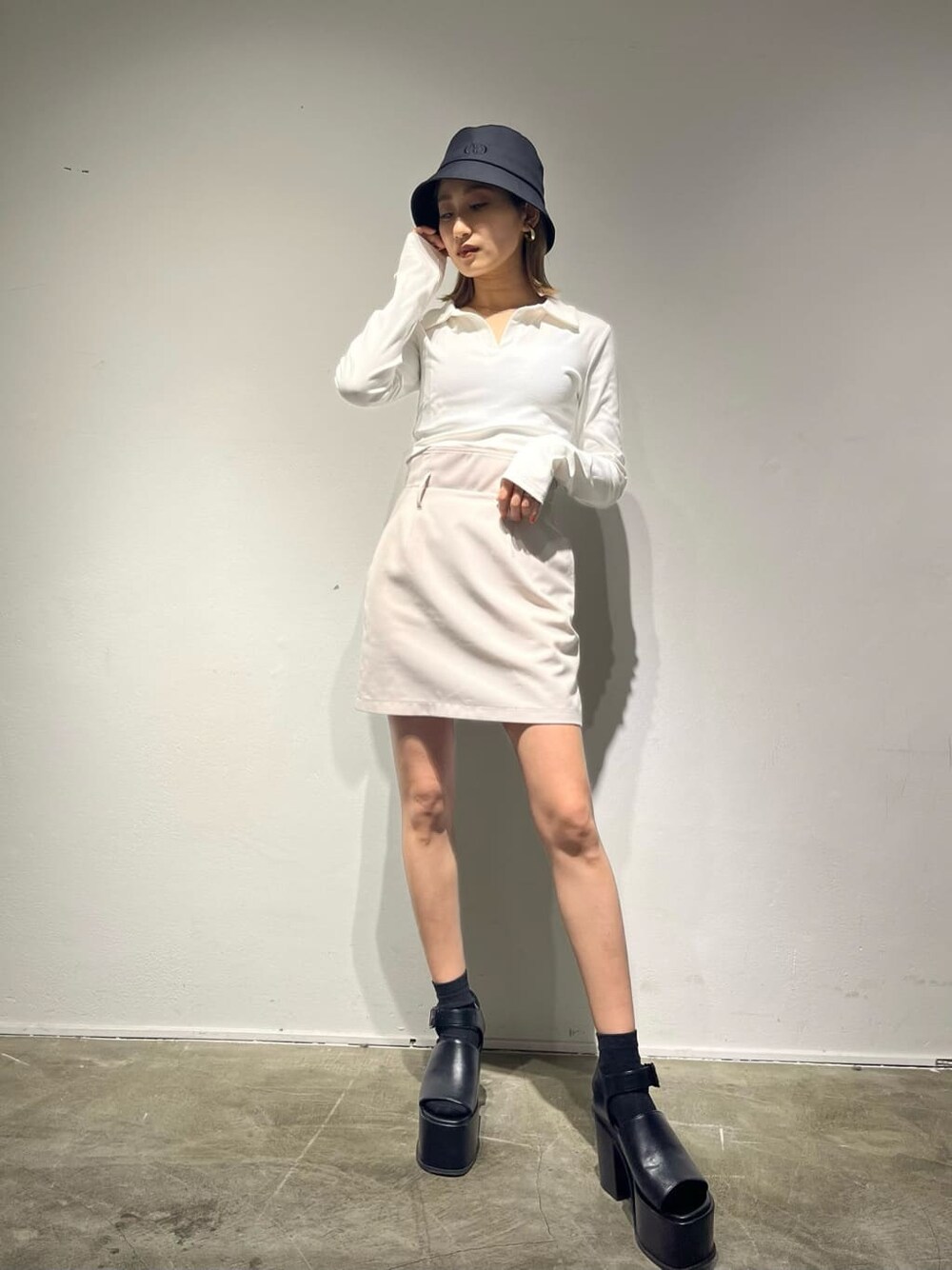 ホワイト系のスカート、イエロー系のTシャツ/カットソー、ブラック系のサンダルを着用したレディースの春コーディネートの1枚目の写真