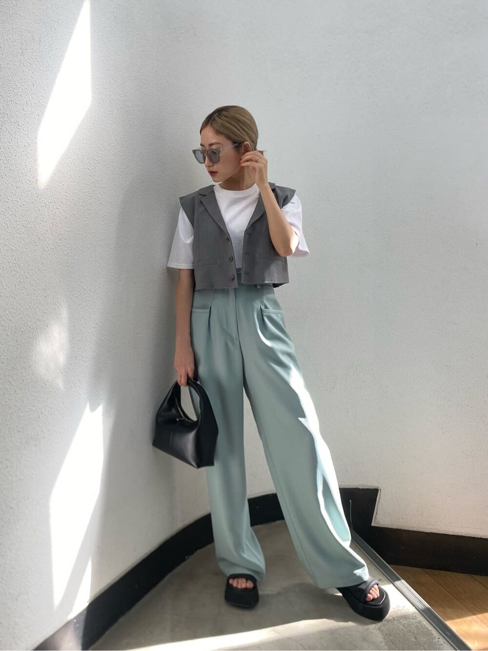ホワイト系のTシャツ/カットソー、ブラック系のサンダル、グレー系のテーラードジャケットを着用したレディースの春コーディネートの1枚目の写真