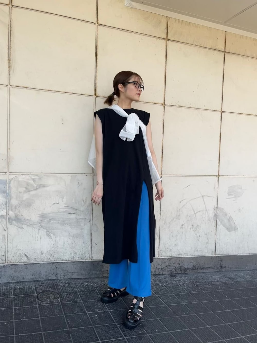 ホワイト系のシャツ/ブラウス、ブルー系のスラックス、ブラック系のサンダルを着用したレディースの夏コーディネートの1枚目の写真