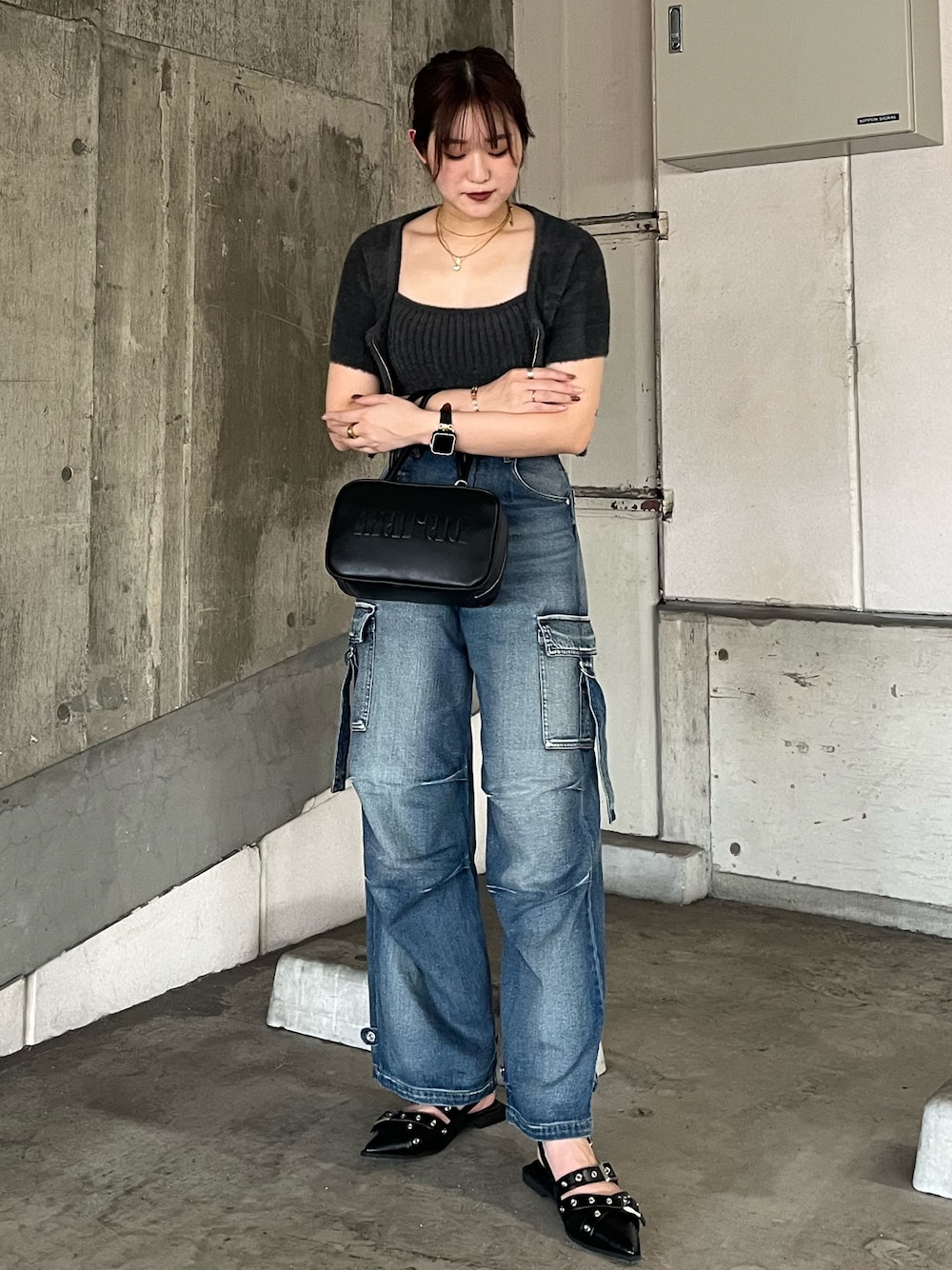 グレー系のニット/セーター、ブルー系のデニムパンツ、ブラック系のパンプスを着用したレディースの秋コーディネートの1枚目の写真