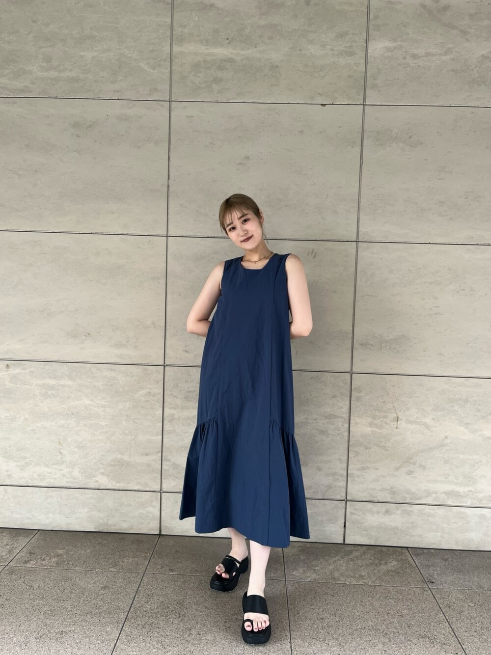 ブルー系のワンピース、ホワイト系のシャツ/ブラウス、ブラック系のサンダルを着用したレディースの夏コーディネートの1枚目の写真