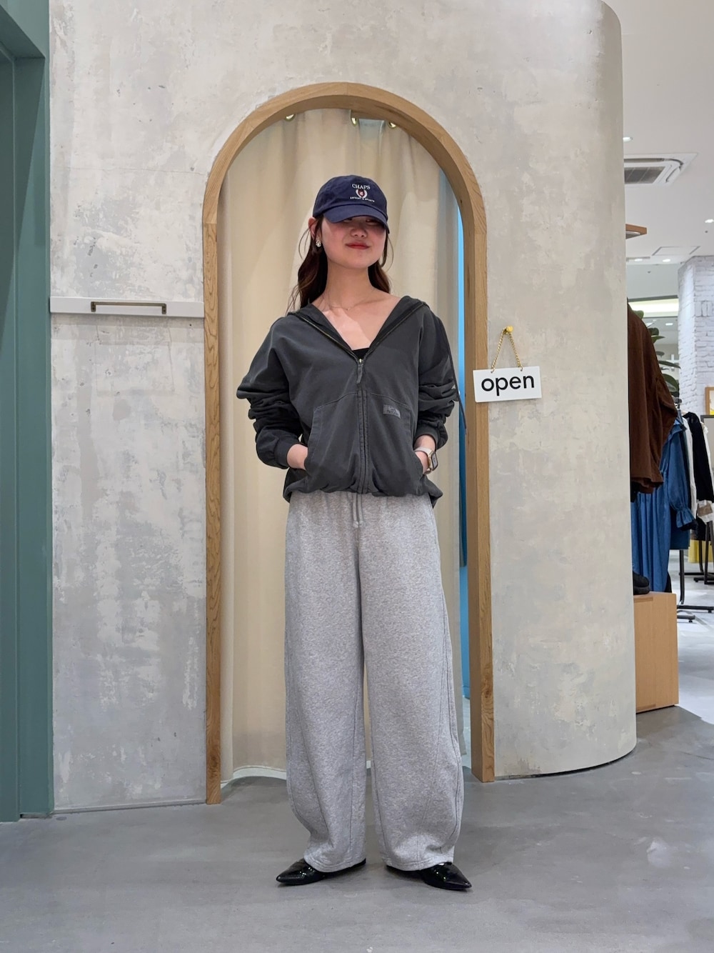 ブラック系のパーカーを着用したレディースの春コーディネートの1枚目の写真