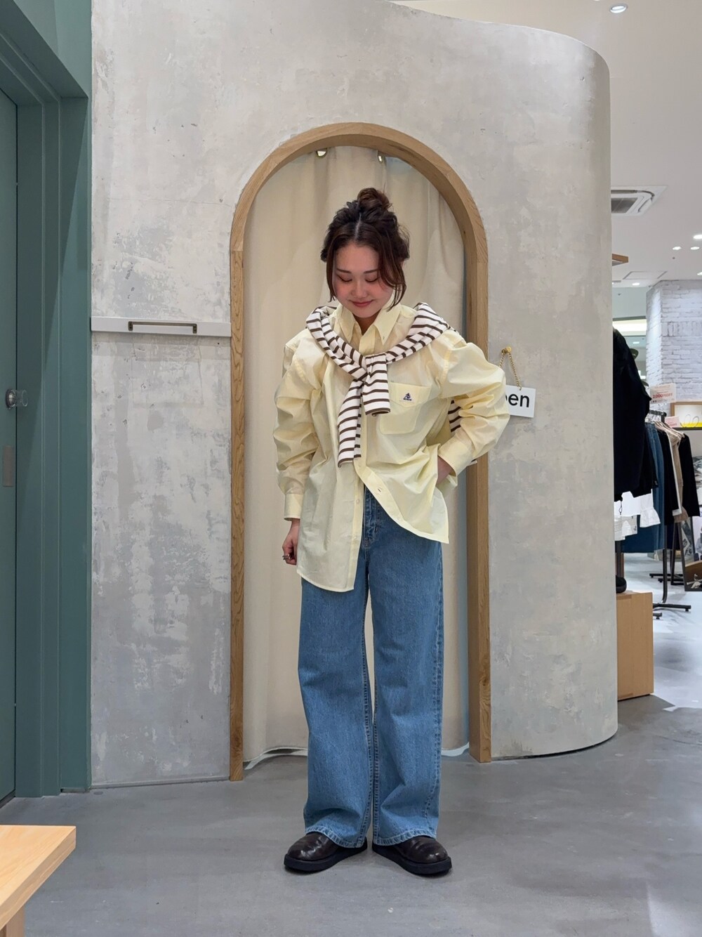 イエロー系のシャツ/ブラウス、ブラウン系のTシャツ/カットソー、ブルー系のデニムパンツを着用したレディースの春コーディネートの1枚目の写真