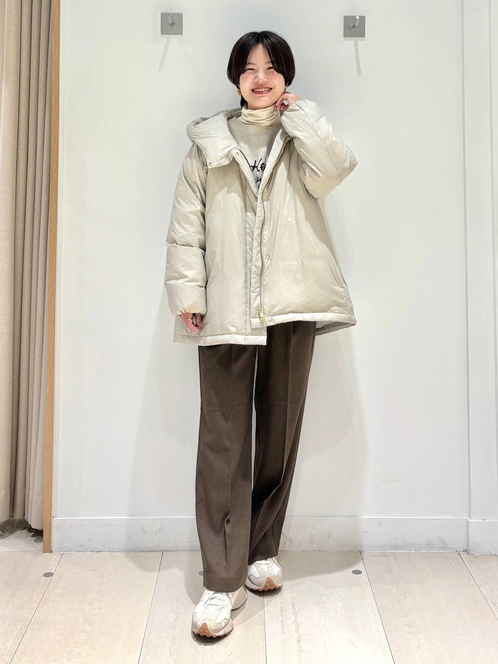 ベージュ系のダウンジャケット/コート、ブラウン系のその他パンツ、ホワイト系のTシャツ/カットソーを着用したレディースの冬コーディネートの1枚目の写真