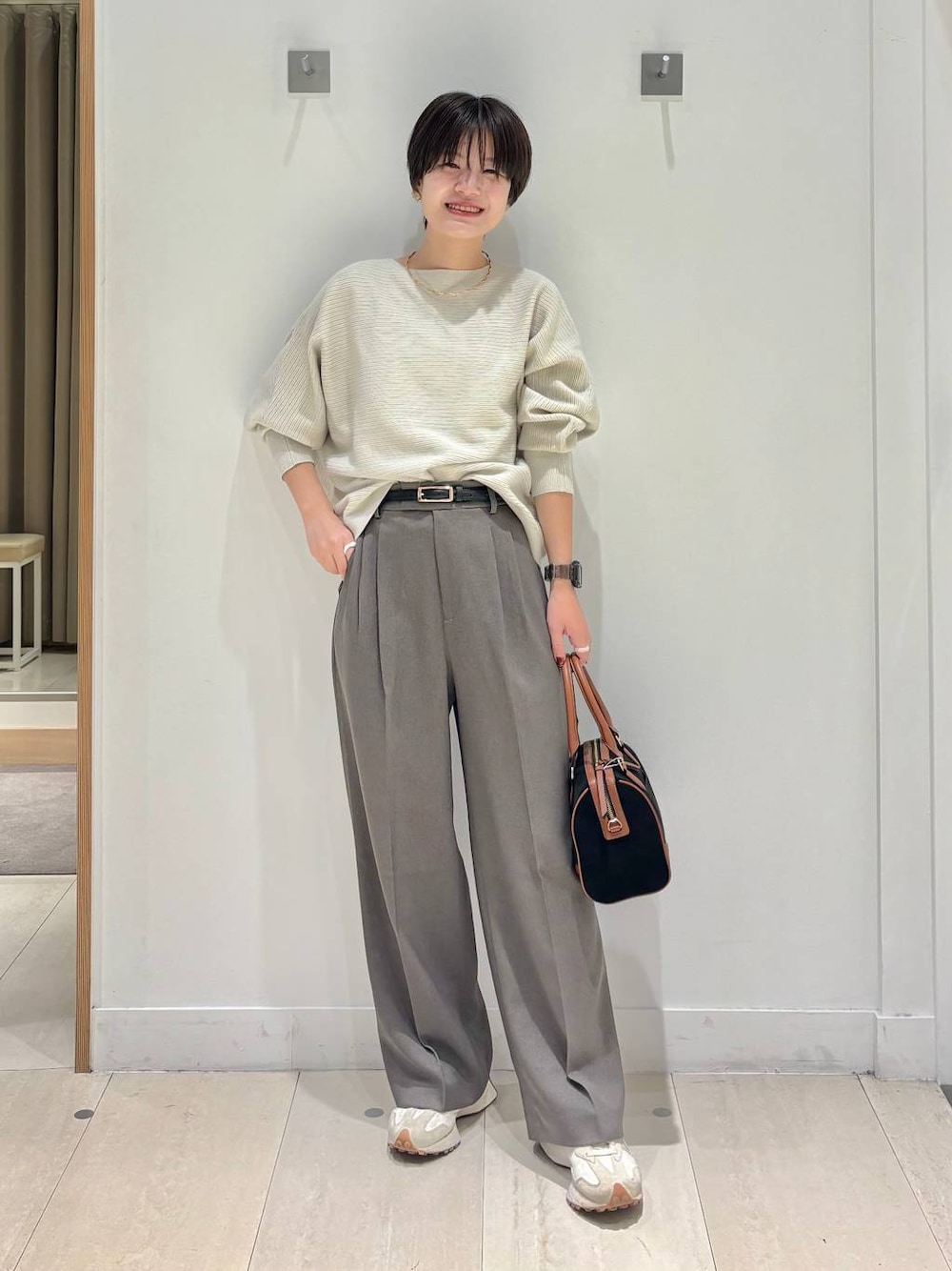 ブラウン系のその他パンツ、グレー系のニット/セーター、ブラック系のボストンバッグを着用したレディースの秋コーディネートの1枚目の写真