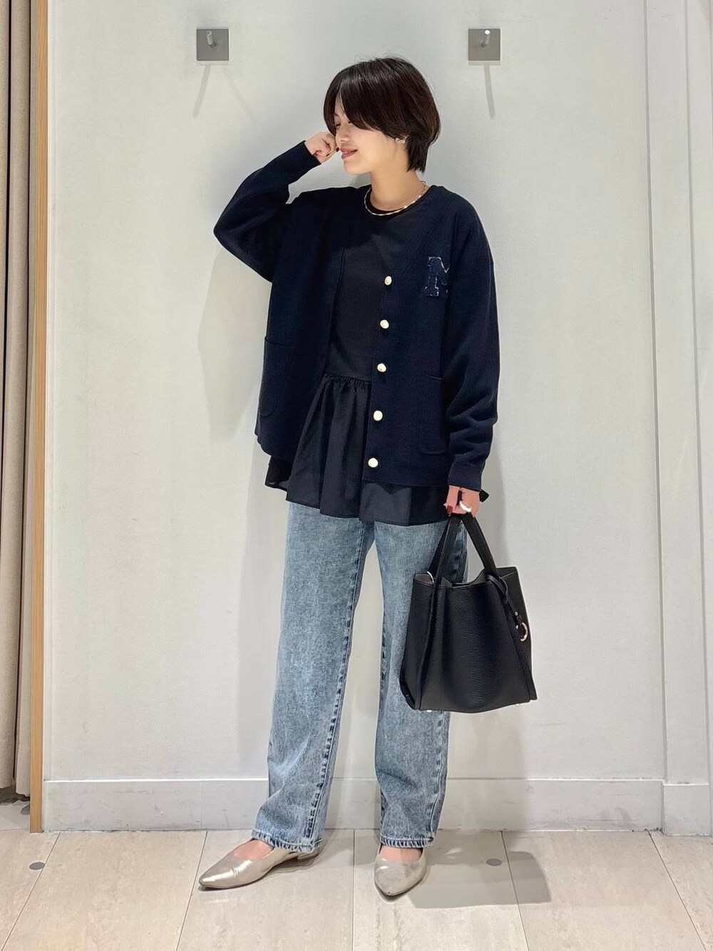 ブルー系のデニムパンツ、ブルー系のカーディガン/ボレロ、ブラック系のトートバッグを着用したレディースの秋コーディネートの1枚目の写真