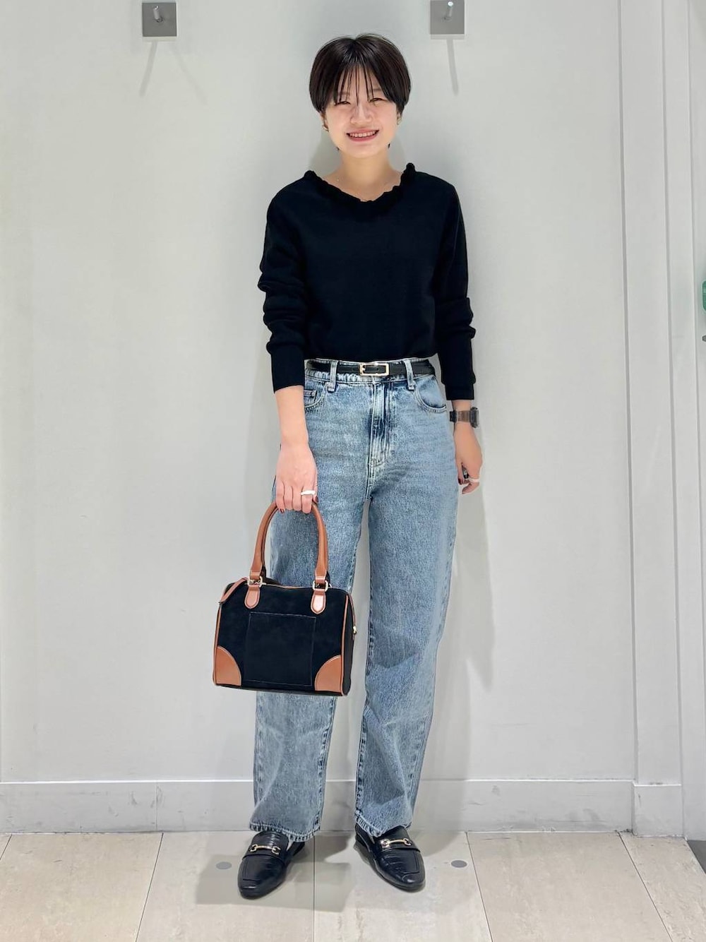 ブラック系のローファー、ブルー系のデニムパンツ、ブラック系のニット/セーターを着用したレディースの秋コーディネートの1枚目の写真