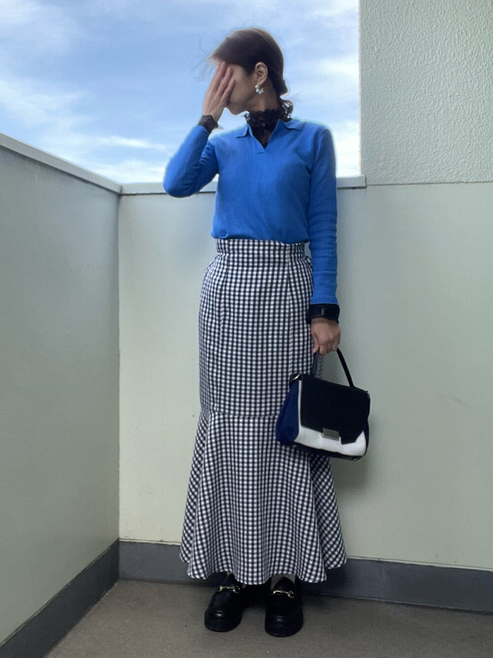 ブラック系のローファー、ブラック系のスカート、その他のバッグを着用したレディースの春コーディネートの1枚目の写真