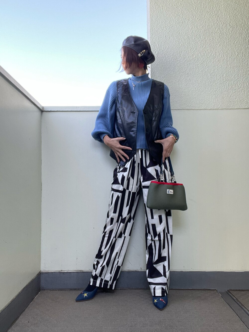 ブラック系のベスト、ホワイト系のその他パンツ、ブルー系のパンプスを着用したレディースの秋コーディネートの1枚目の写真