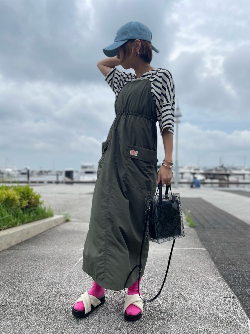 グリーン系のワンピース、ホワイト系のサンダル、ホワイト系のMA-1を着用したレディースの夏コーディネートの1枚目の写真