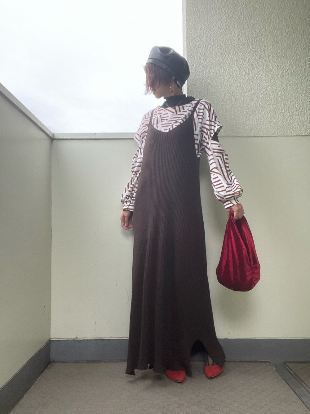 レッド系のバッグ、レッド系のパンプス、ブラウン系のワンピースを着用したレディースの秋コーディネートの1枚目の写真