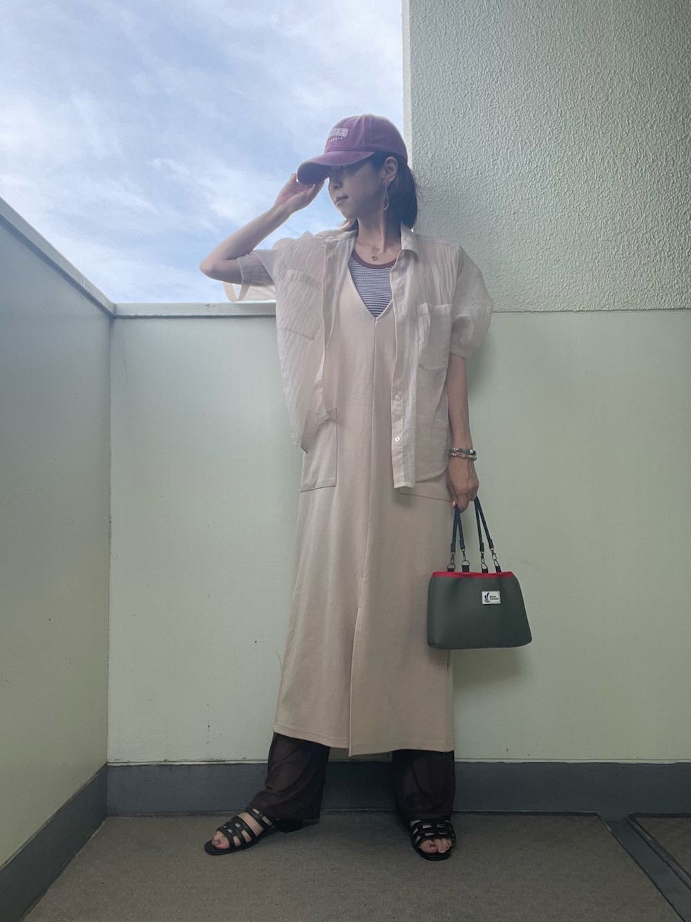 ベージュ系のワンピース/ドレス、グリーン系のバッグ、ブラウン系のタンクトップを着用したレディースの夏コーディネートの1枚目の写真