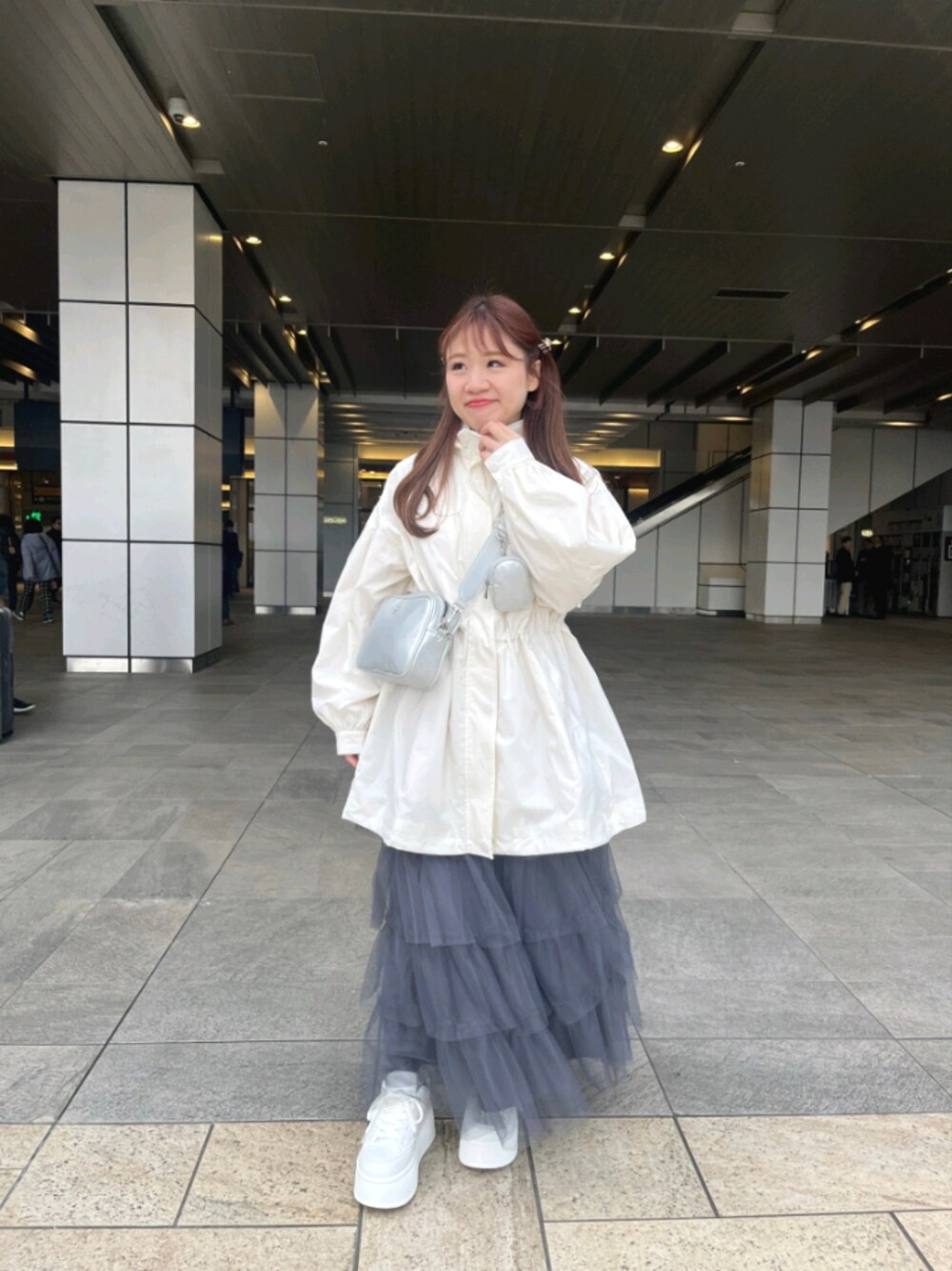 ホワイト系のマウンテンパーカー、グレー系のスカート、シルバー系のボディバッグ/ウエストポーチを着用したレディースの春コーディネートの1枚目の写真