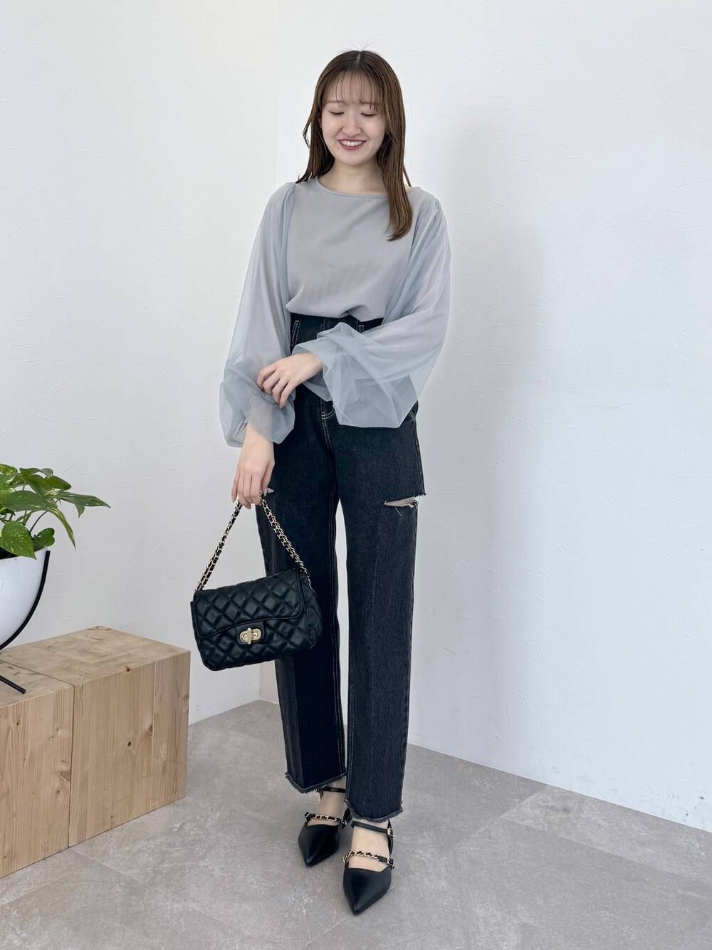 グレー系のTシャツ/カットソー、ブラック系のショルダーバッグ、ブラック系のデニムパンツを着用したレディースの冬コーディネートの1枚目の写真