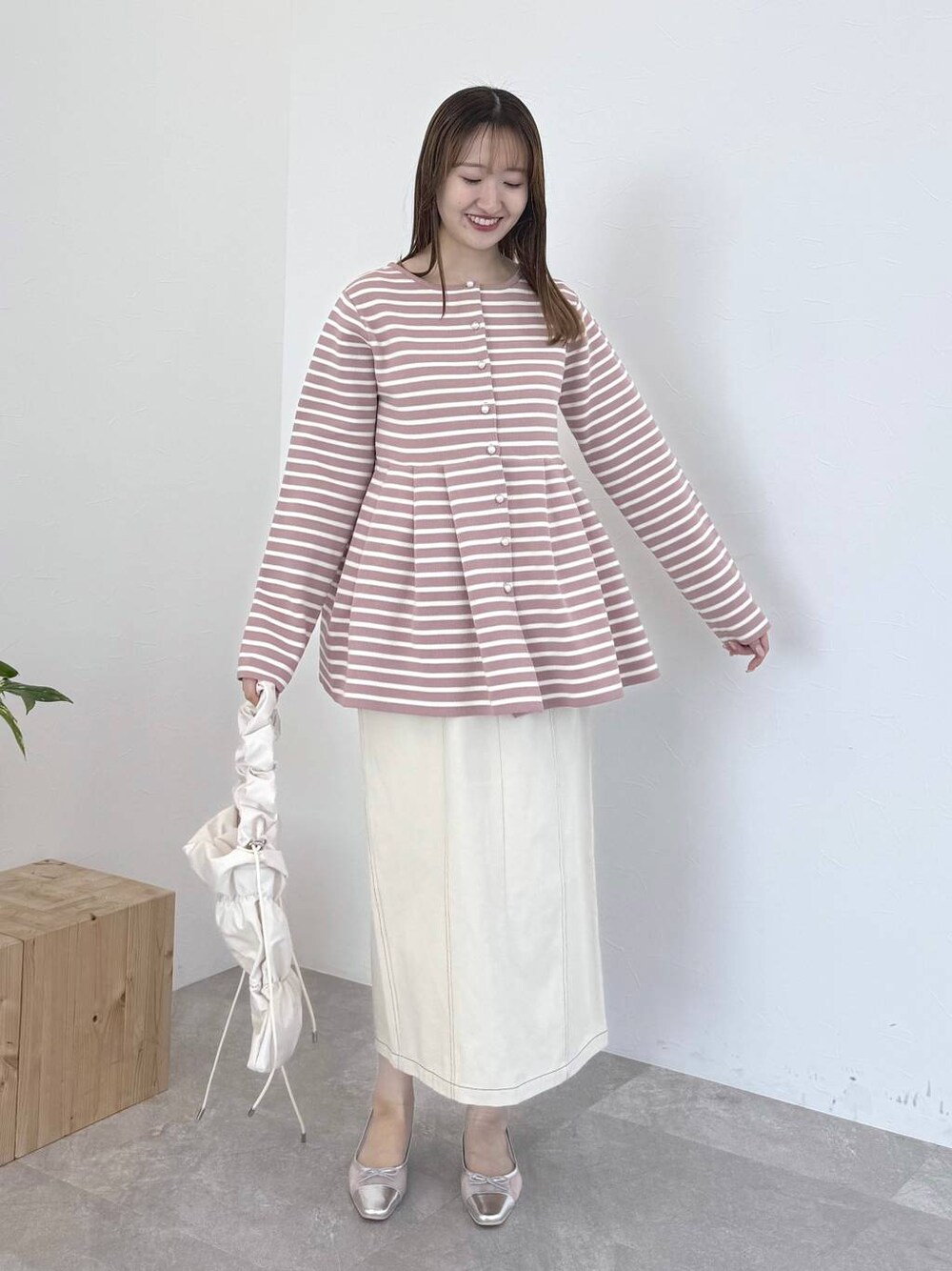 ピンク系のカーディガン/ボレロ、シルバー系のバレエシューズ、ホワイト系のスカートを着用したレディースの春コーディネートの1枚目の写真