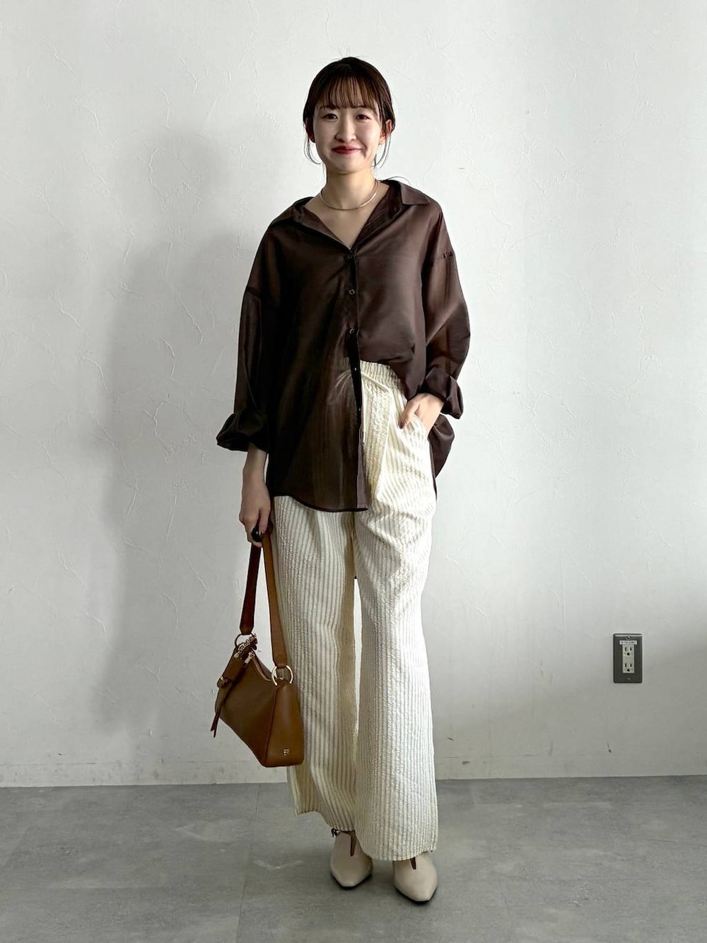 ブラウン系のシャツ/ブラウス、ホワイト系のサンダル、ベージュ系のその他パンツを着用したレディースの春コーディネートの1枚目の写真