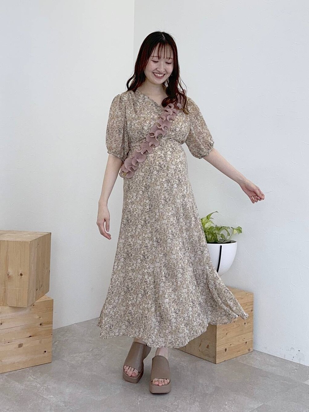 ベージュ系のサンダル、ベージュ系のワンピース、ピンク系のスマホグッズを着用したレディースの夏コーディネートの1枚目の写真