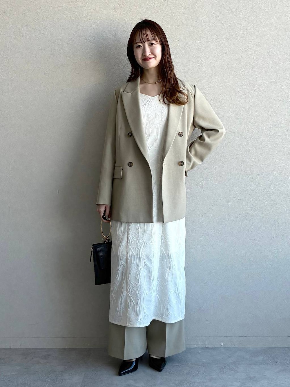 ベージュ系のテーラードジャケット、ベージュ系のその他パンツ、ホワイト系のワンピースを着用したレディースの冬コーディネートの1枚目の写真