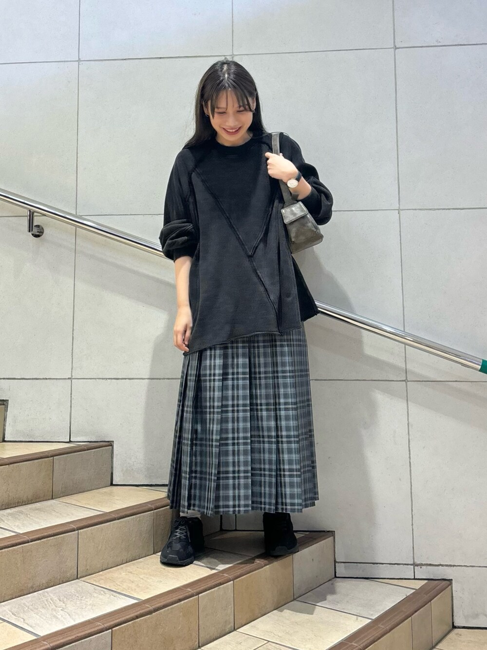 ブラック系のTシャツ/カットソー、ブルー系のスカート、グレー系のハンドバッグを着用したレディースの秋コーディネートの1枚目の写真