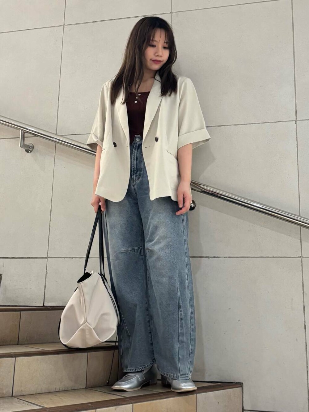 シルバー系のローファー、ブルー系のデニムパンツ、ベージュ系のトートバッグを着用したレディースの夏コーディネートの1枚目の写真