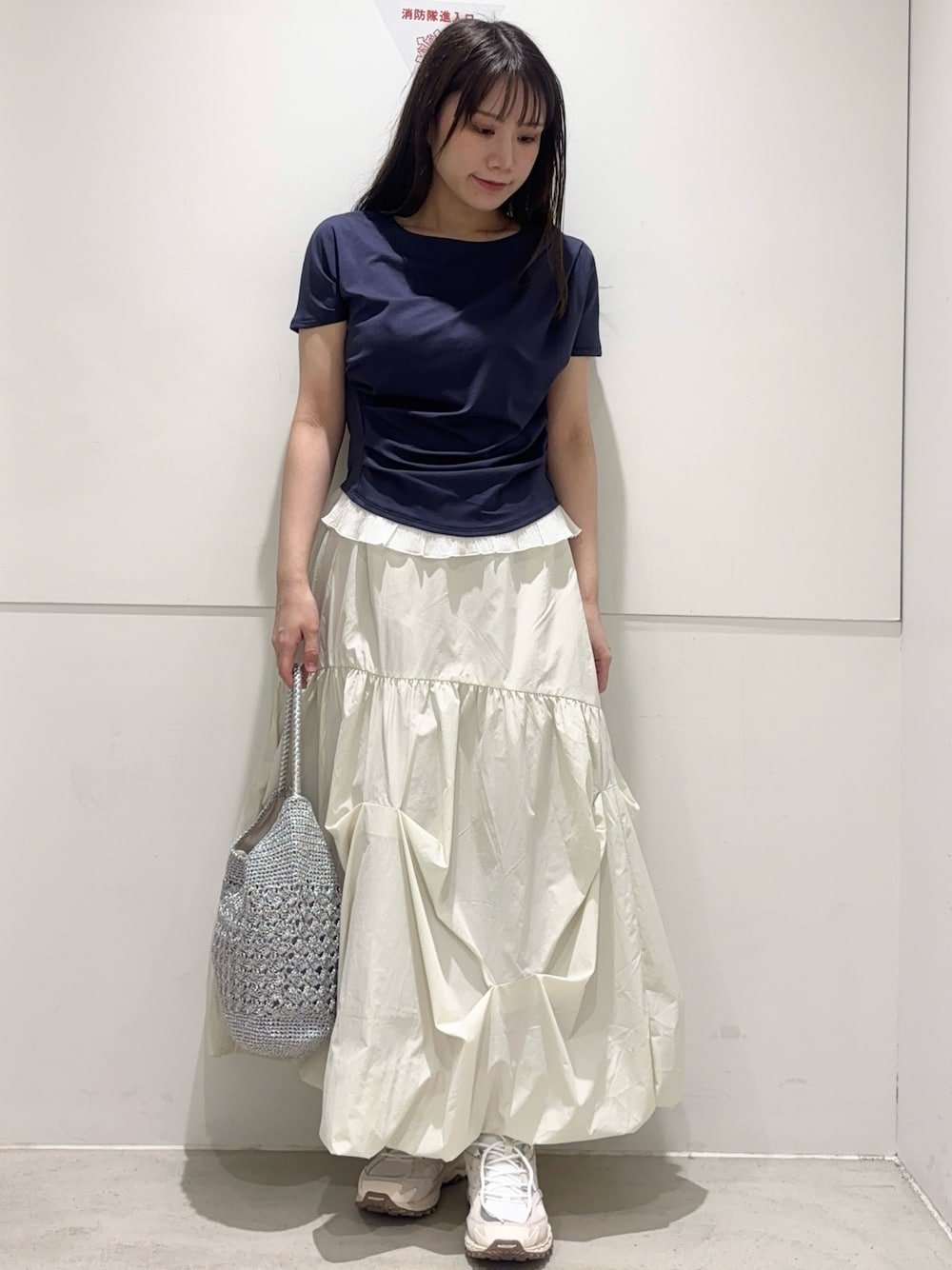 ブルー系のTシャツ/カットソー、ホワイト系のスカート、シルバー系のかごバッグを着用したレディースの春コーディネートの1枚目の写真