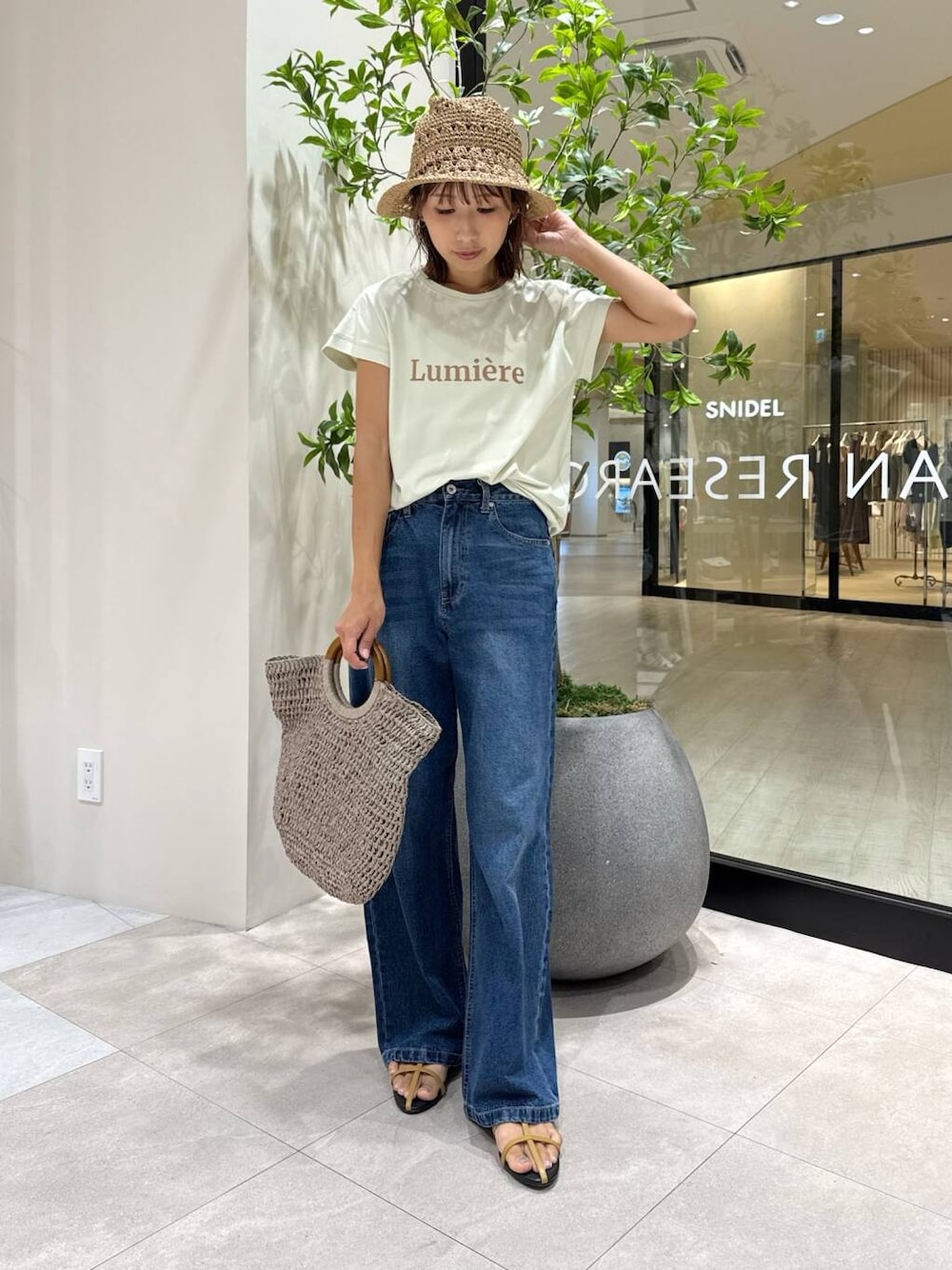 ブラウン系のサンダル、グレー系のトートバッグ、グリーン系のTシャツ/カットソーを着用したレディースの夏コーディネートの1枚目の写真
