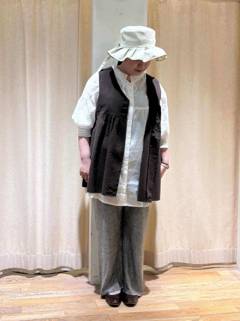 ブラック系のベスト、ホワイト系のシャツ/ブラウス、グレー系のその他パンツを着用したレディースの春コーディネートの1枚目の写真