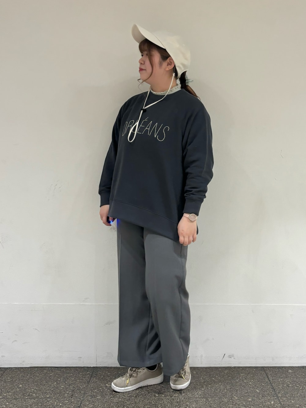 グレー系のTシャツ/カットソー、グレー系のスラックス、ホワイト系のハットを着用したレディースの冬コーディネートの1枚目の写真