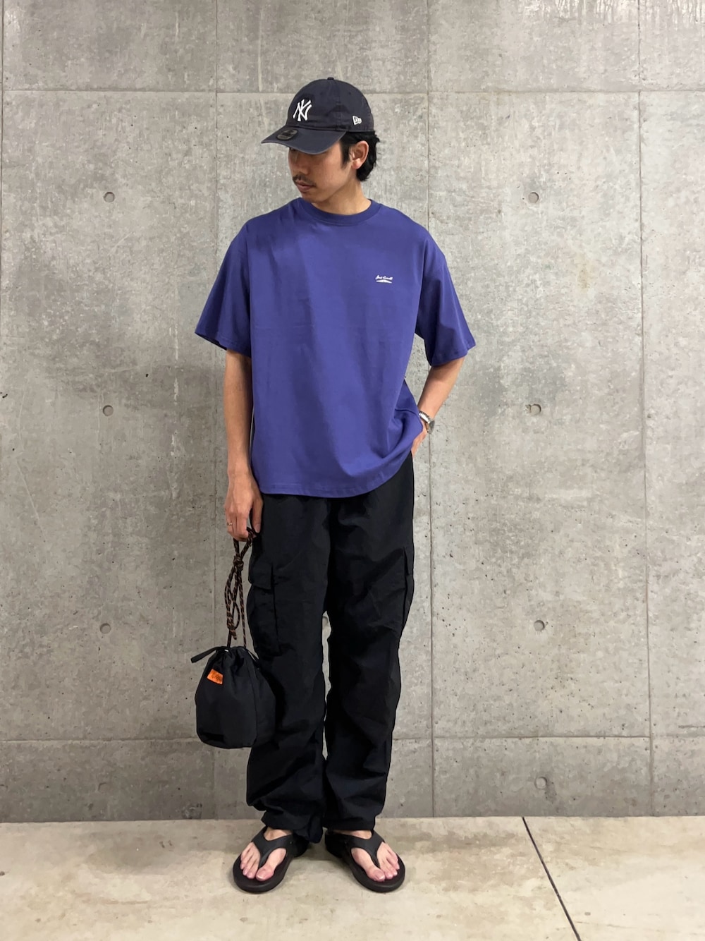 「大人カジュアル、最近のいい感じコーデ、お出かけコーデ、アウトドアスタイル、スポーツミックス、キャップ、シンプルコーデ、夏コーデ、サンダル、oofos、巾着バッグ、ダークカラー、Tシャツ、コンバース、ジャックパーセル」｜「JACK PURCELLの【Jack Purcell/ジャックパーセル】コーマ天竺 バックプリント グラフィックTシャツ（Tシャツ/カットソー、ブルー系）」を使った、ハヤシさん（骨格ストレート・メンズ・183cm）の春コーディネートの1枚目の写真