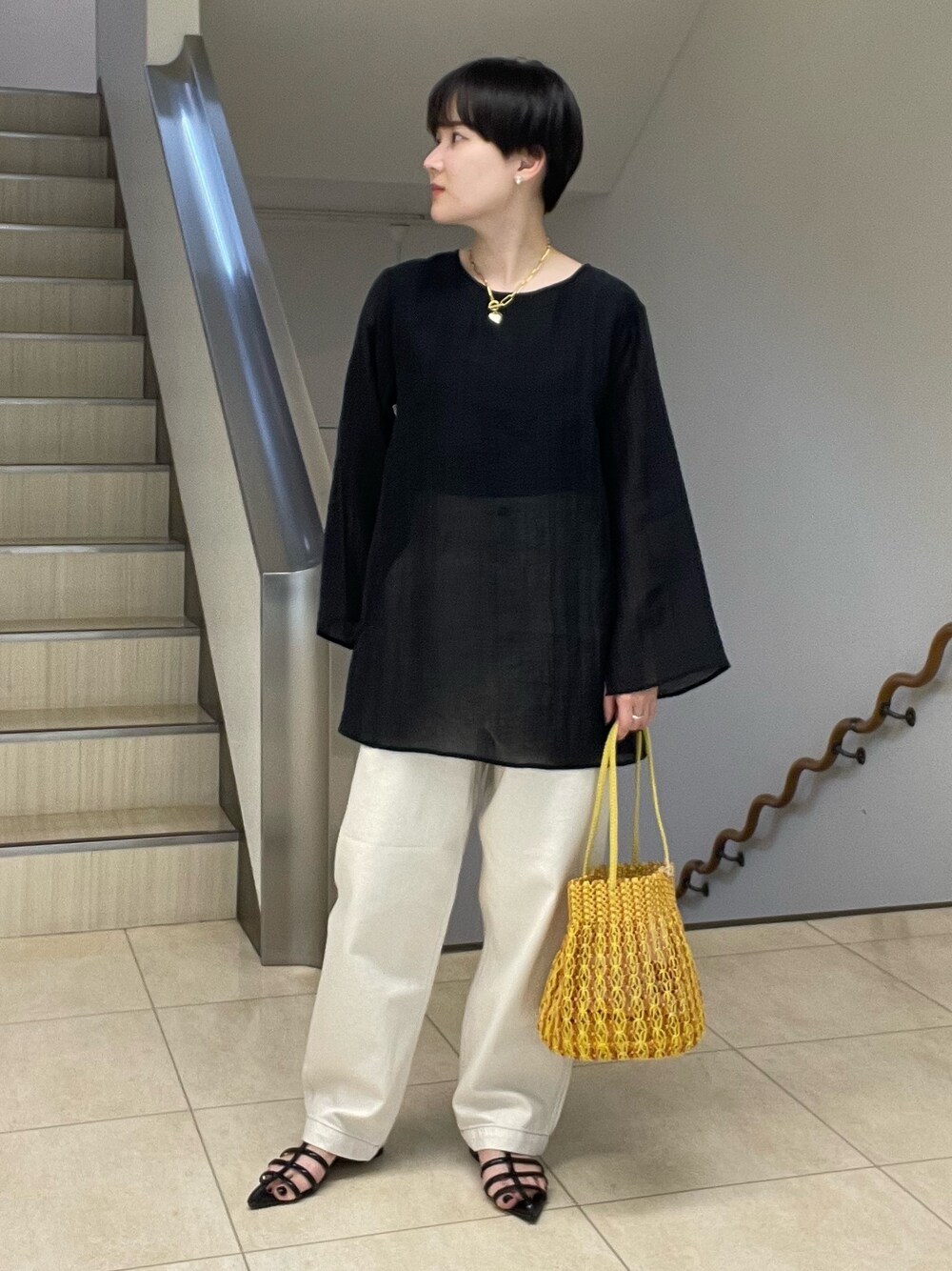 ブラック系のシャツ/ブラウス、ホワイト系のデニムパンツ、イエロー系のショルダーバッグを着用したレディースの春コーディネートの1枚目の写真