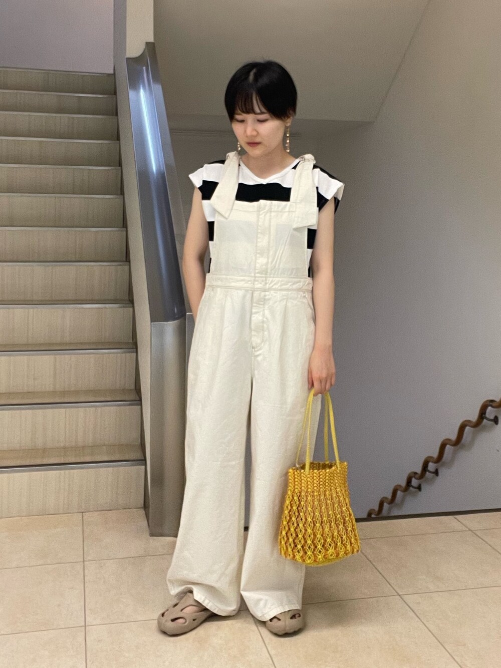 ブラック系のTシャツ/カットソー、ホワイト系のサロペット/オーバーオール、ブルー系のショルダーバッグを着用したレディースの夏コーディネートの1枚目の写真