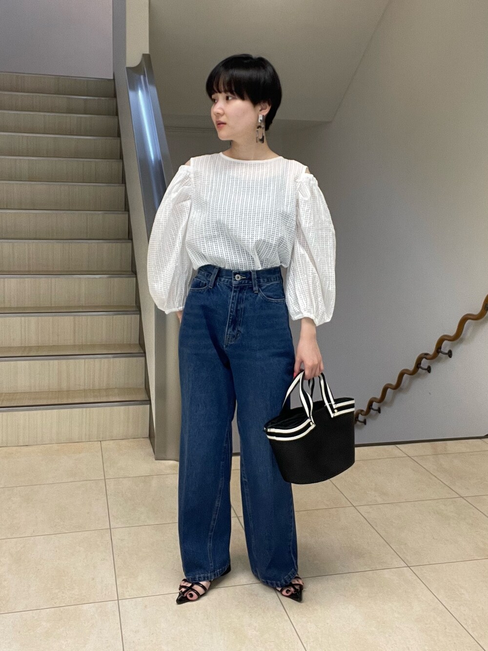 ホワイト系のシャツ/ブラウス、ブルー系のデニムパンツ、ブラック系のトートバッグを着用したレディースの春コーディネートの1枚目の写真