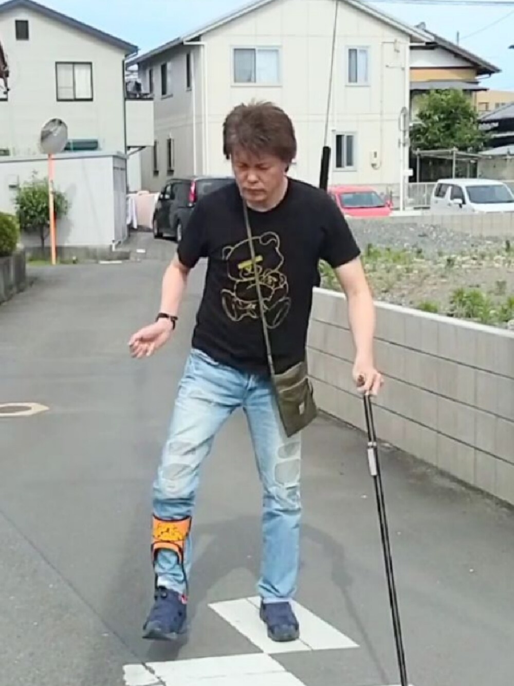 ブラック系のTシャツ/カットソー、グリーン系のショルダーバッグ、ブルー系のデニムパンツを着用したメンズの夏コーディネートの1枚目の写真