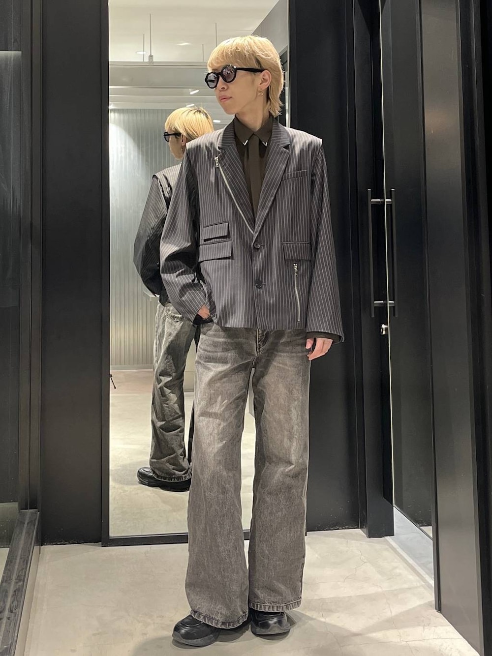 ブラウン系のデニムパンツ、グレー系のテーラードジャケット、ブラウン系のシャツ/ブラウスを着用したメンズの冬コーディネートの1枚目の写真