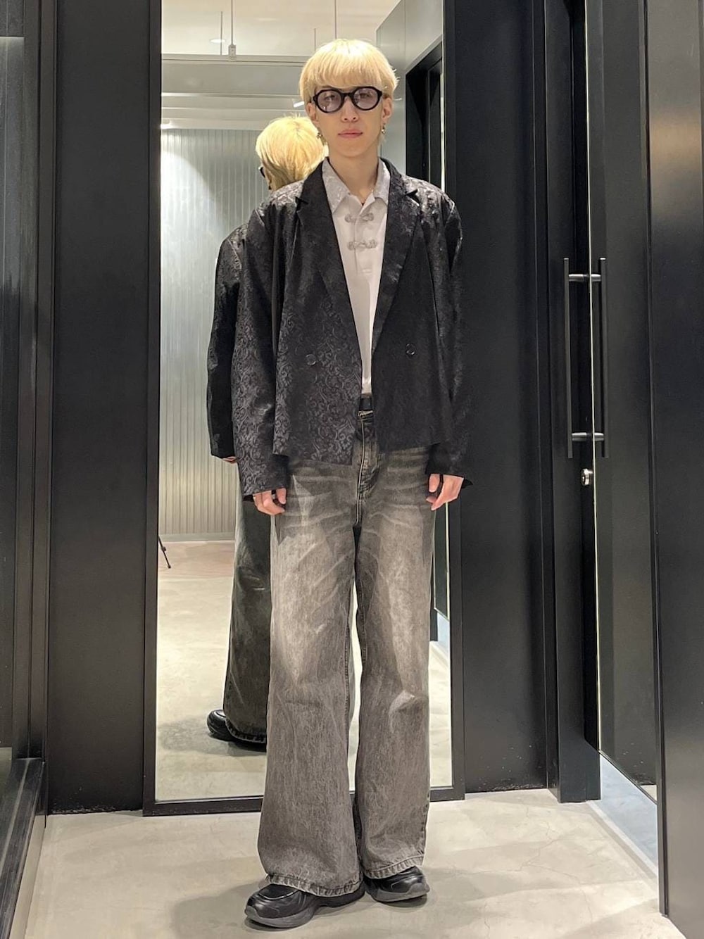 ブラウン系のデニムパンツ、ブラック系のテーラードジャケット、グレー系のシャツ/ブラウスを着用したメンズの春コーディネートの1枚目の写真