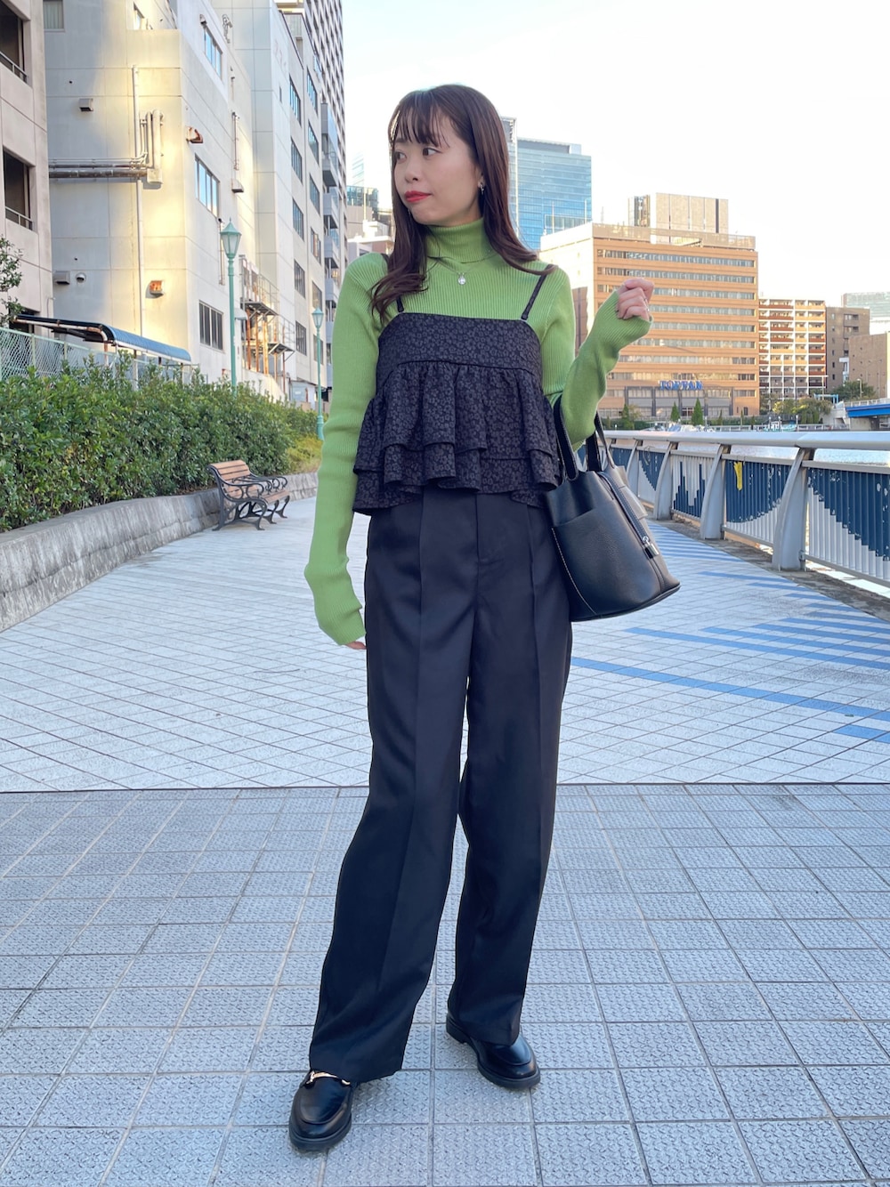 グリーン系のニット/セーター、ブラック系のキャミソール、ブラック系のスラックスを着用したレディースの秋コーディネートの1枚目の写真