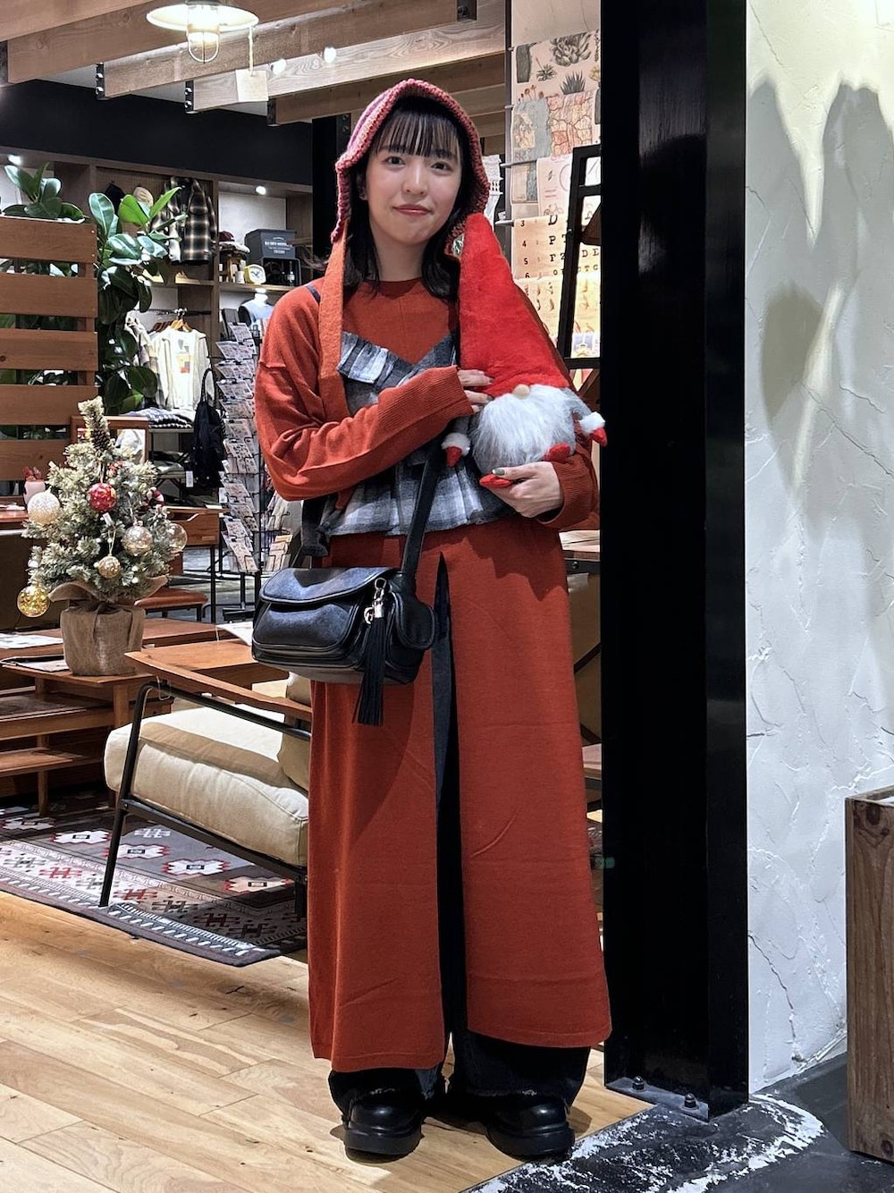 ブラック系のデニムパンツ、ブラック系のキャミソール、ブラック系のショルダーバッグを着用したレディースの秋コーディネートの1枚目の写真