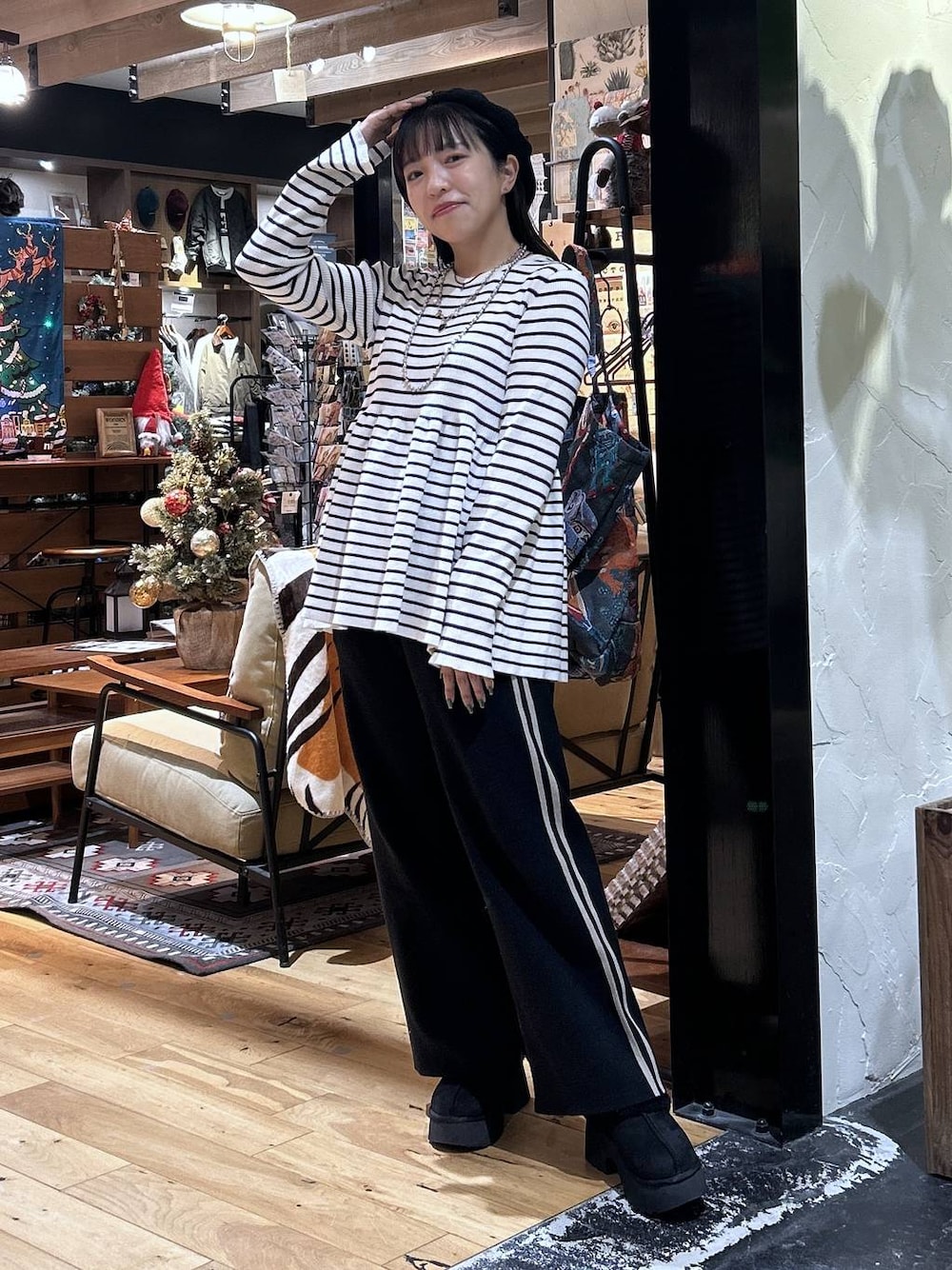 ブラック系のその他パンツ、ベージュ系のニット/セーター、ブラック系のブーツを着用したレディースの秋コーディネートの1枚目の写真