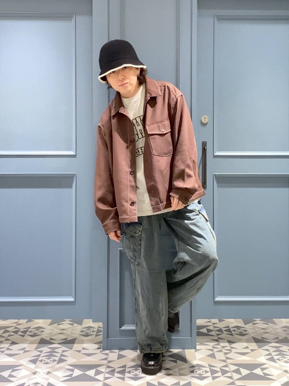ブルー系のデニムパンツ、ブラウン系のブルゾン、ブラック系のドレスシューズを着用したメンズの秋コーディネートの1枚目の写真