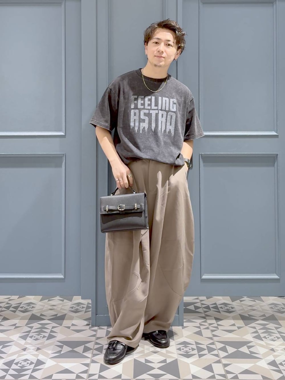 ベージュ系のスラックス、グレー系のTシャツ/カットソー、ブラック系のローファーを着用したメンズの秋コーディネートの1枚目の写真