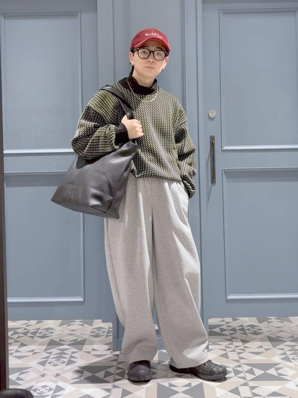 ブラック系のスニーカー、ブラック系のトートバッグ、ブラック系のTシャツ/カットソーを着用したメンズの冬コーディネートの1枚目の写真