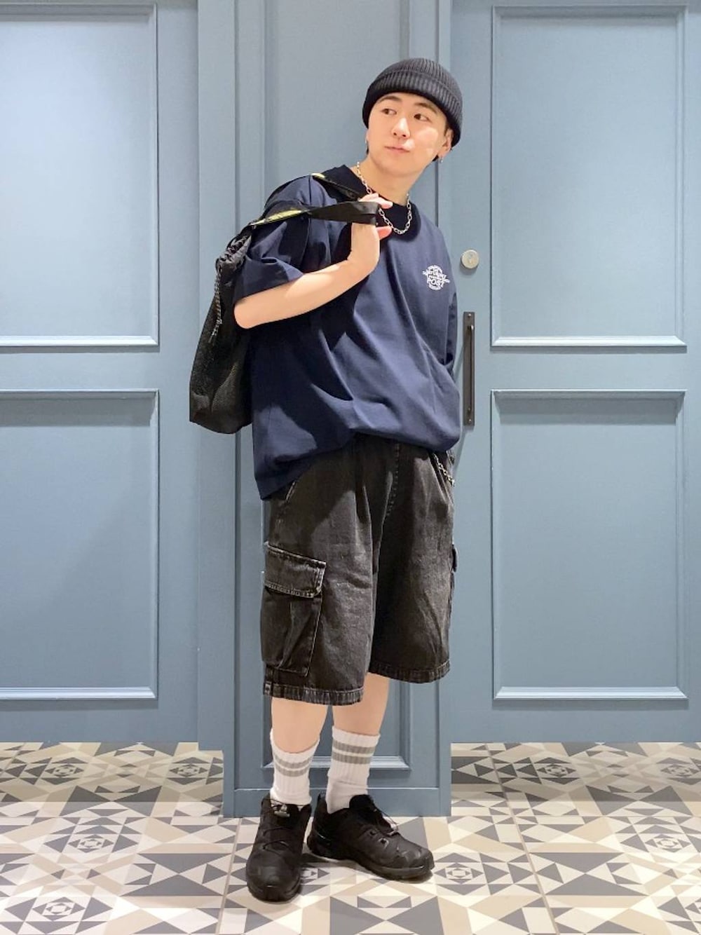 ブラック系のスニーカー、グレー系のカーゴパンツ、ブラック系のトートバッグを着用したメンズの春コーディネートの1枚目の写真