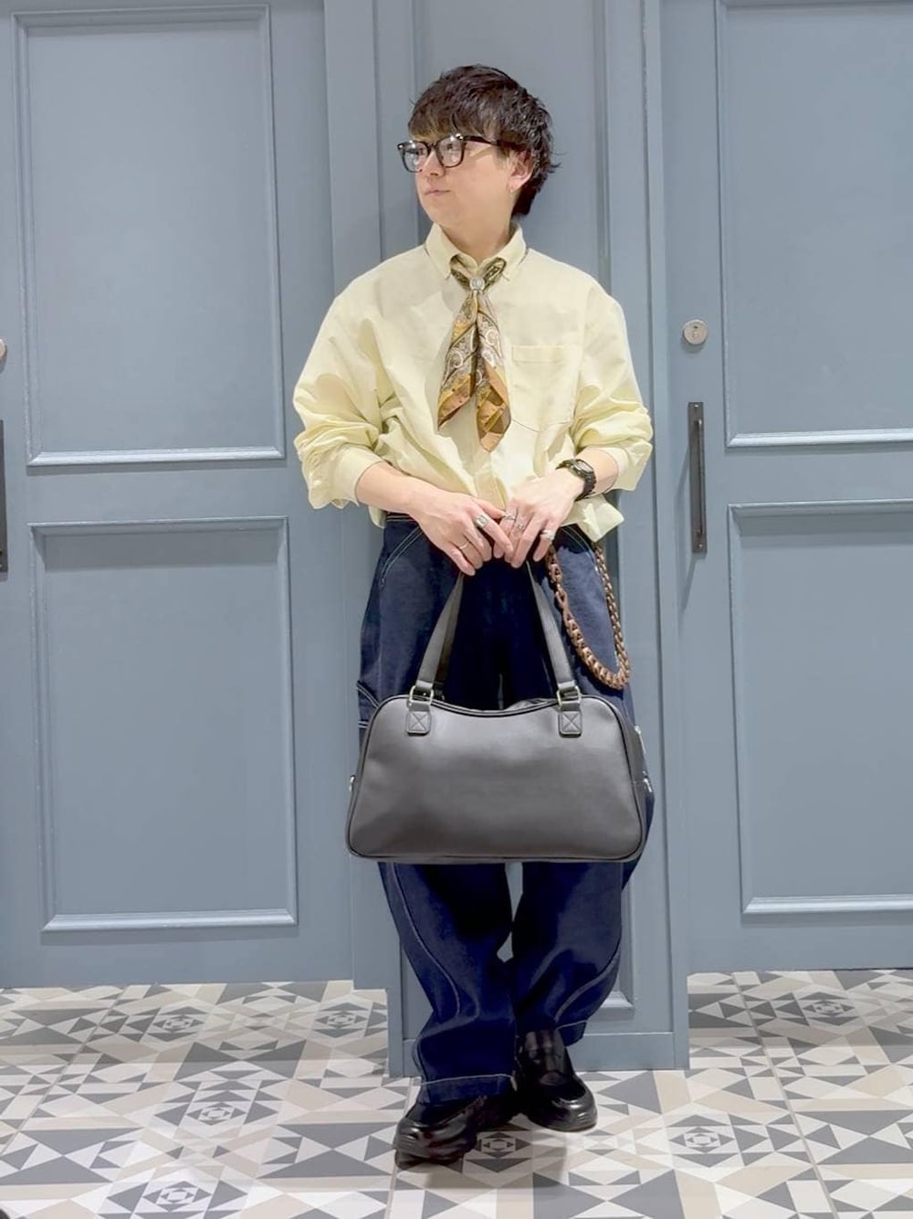 ブラック系のローファー、イエロー系のシャツ/ブラウス、ブルー系のデニムパンツを着用したメンズの春コーディネートの1枚目の写真