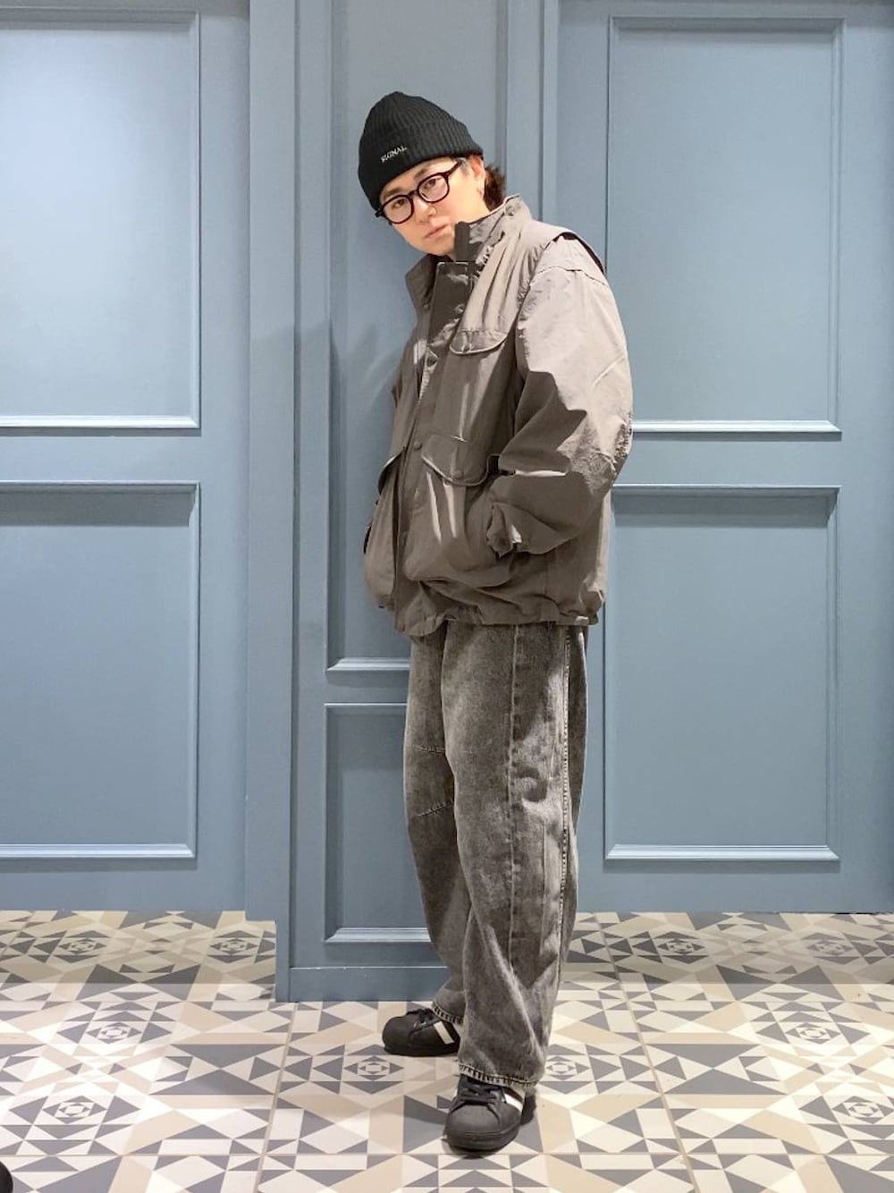 グレー系のデニムパンツ、グレー系のブルゾン、ブルー系のニット/セーターを着用したメンズの秋コーディネートの1枚目の写真