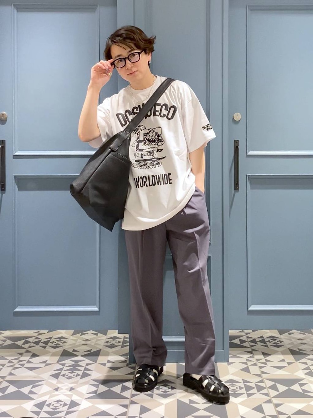 ブラック系のショルダーバッグ、グレー系のスラックス、ブラック系のサンダルを着用したメンズの春コーディネートの1枚目の写真