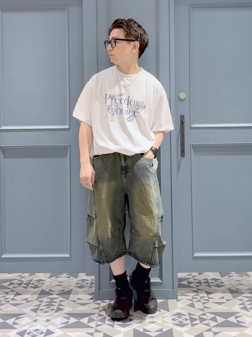 ホワイト系のTシャツ/カットソー、ブルー系のデニムパンツ、ブラック系のスニーカーを着用したメンズの秋コーディネートの1枚目の写真