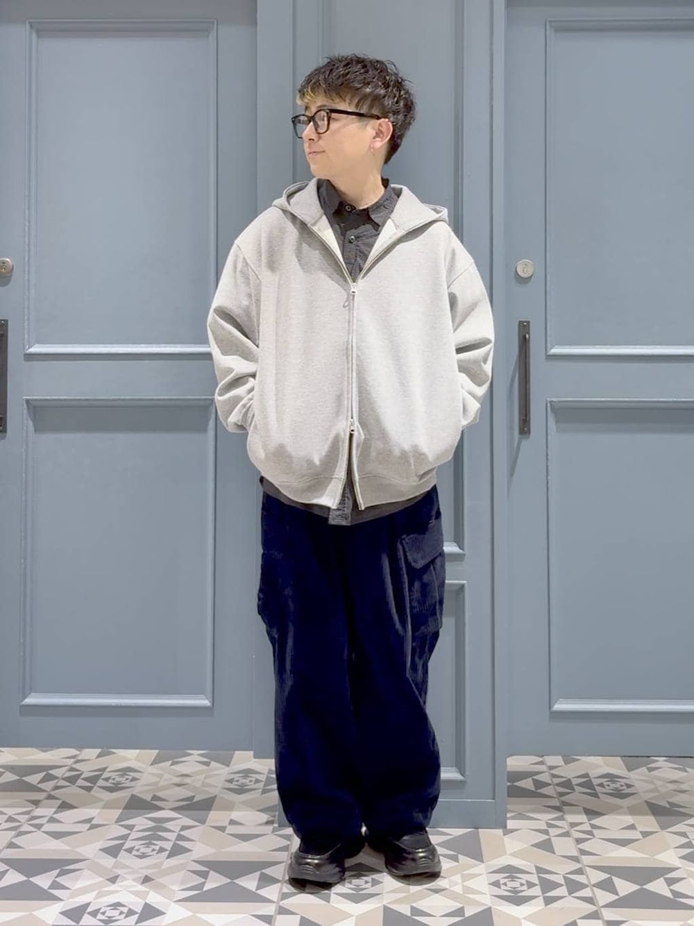 ブルー系のカーゴパンツ、ブラック系のローファー、ブラック系のシャツ/ブラウスを着用したメンズの冬コーディネートの1枚目の写真